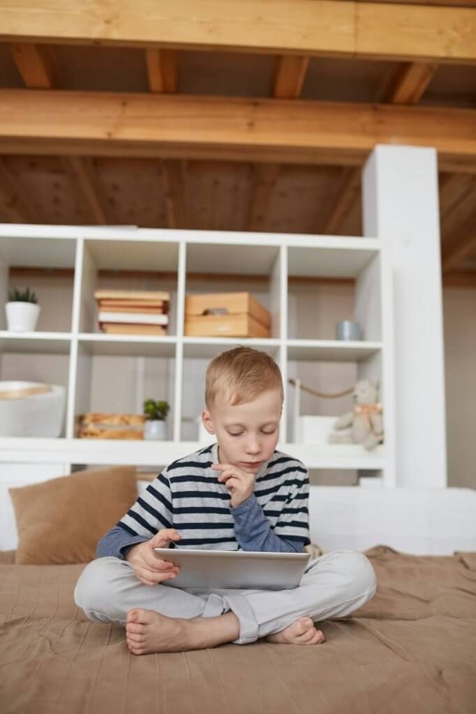 Thoughtful boy watching educational film